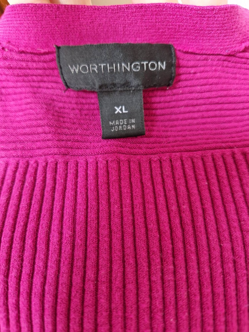 May include: A magenta ribbed sweater with a black tag that reads "Worthington" and "XL Made in Jordan."