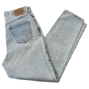Puede incluir: Vaqueros de mezclilla azul claro con un diseño clásico de cinco bolsillos. Los vaqueros presentan un lavado descolorido y un parche de cuero en la parte trasera con el texto "GAP BLUE JEANS". Los vaqueros están doblados y colocados planos.