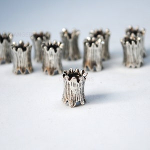 Peut inclure: Des embouts de perles en métal argenté avec un bord festonné décoratif. Les embouts sont conçus pour être utilisés pour la fabrication de bijoux ou d'autres projets d'artisanat.