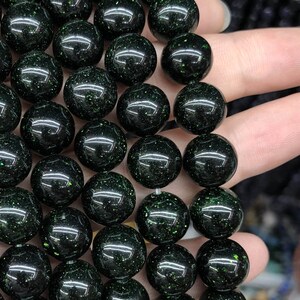 Peut inclure: Un brin de perles rondes vert foncé avec une finition brillante et scintillante.