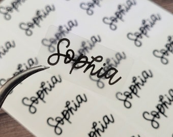 May include: A sheet of clear, transparent stickers with the name "Sophia" written in cursive on each sticker.