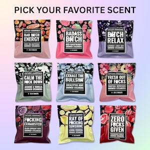 May include: Nine colorful shower steamer packages with bold text and floral designs. Scents include Sweet Red Grapefruit, Red Raspberry, Lavender & Sweet Mint, Jasmine & Vanilla, Eucalyptus Mint, Tropical Refresher, Black Currant Rose, Lemon Verbena, and Pomegranate Vanilla.