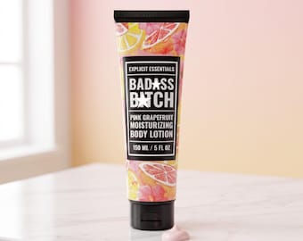May include: A squeeze tube of Explicit Essentials Badass Batch Pink Grapefruit Moisturizing Body Lotion. The tube features a black label with white text and a colorful citrus and floral pattern. It contains 150 ml or 5 fl oz of product.