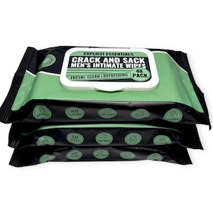 May include: Three stacked packages of intimate wipes. The packages are black with a green and white label. The label reads "CRACK AND SACK MEN'S INTIMATE WIPES" and "FRESH CLEAN REFRESHING". Each package contains 40 wipes.