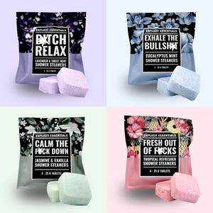 May include: Four pouches of Explicit Essentials shower steamers in lavender, eucalyptus mint, jasmine vanilla, and tropical scents. Each pouch contains four 25g tablets, featuring floral and botanical patterns with bold text labels on the front packaging.