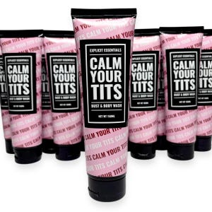 May include: Pink and black tubes of "Calm Your Tits" bust and body wash. The tubes have a black cap and a label with the product name in large white letters. The brand name "Explicit Essentials" is also on the label. The net weight is 150ml.