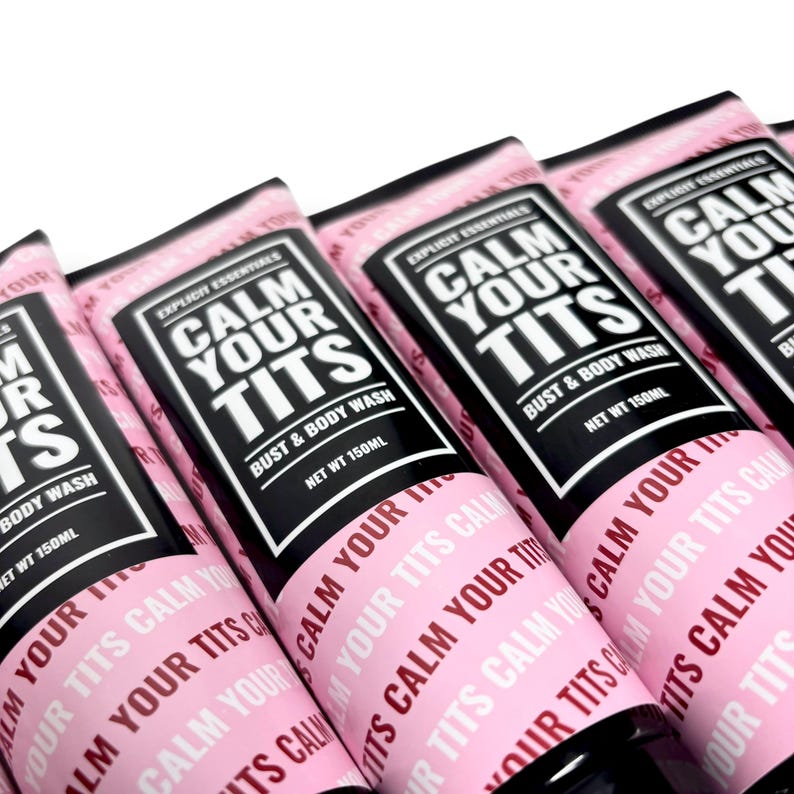 May include: Several pink tubes of "Calm Your Tits" bust and body wash, each with a black label and white text. The tubes are labeled "Explicit Essentials" and contain 150ml of product. The phrase "Calm Your Tits" is repeated on the tube.