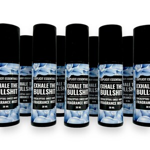 Puede incluir: Varias botellas de spray negras con etiquetas que dicen "EXHALE THE BULLSHIT" y "Eucalyptus Sweet Mint Fragrance Mist". Las etiquetas presentan un dise&ntilde;o floral azul. Cada botella contiene 30 ml.
