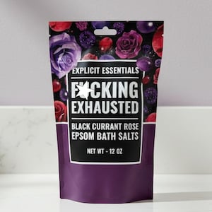 May include: A purple bag of Epsom bath salts with the text "F*CKING EXHAUSTED". The bag has a floral design with roses and berries. The net weight is 12 oz.