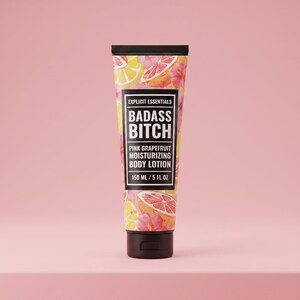 May include: A squeeze tube of pink grapefruit moisturizing body lotion with a black cap. The label features a pattern of citrus slices and pink flowers, with the text Explicit Essentials, Badass Bitch, and 150 ml / 5 fl oz printed on the front.
