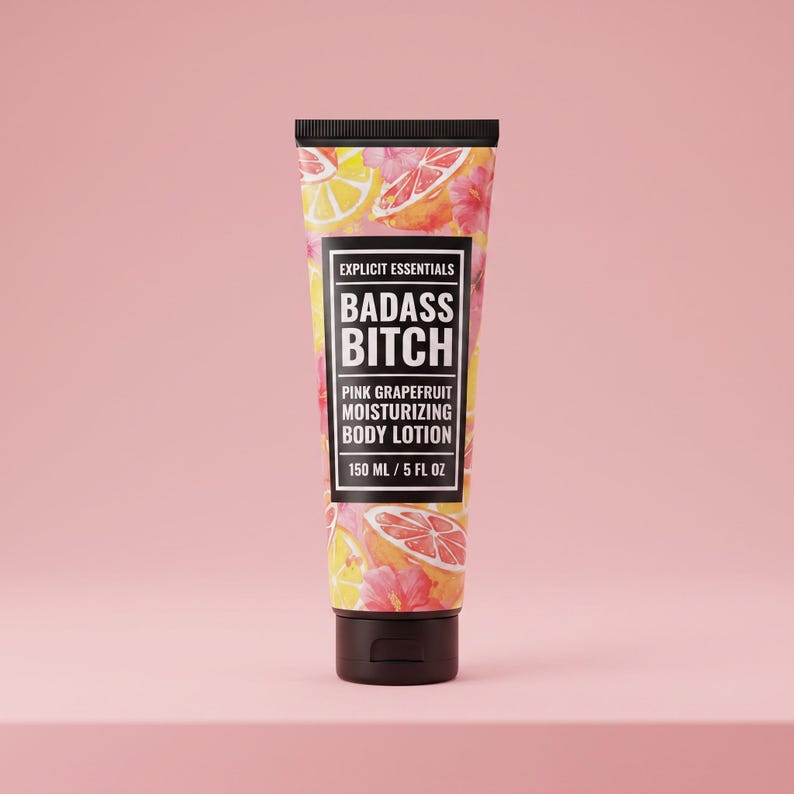 May include: A squeeze tube of pink grapefruit moisturizing body lotion with a black cap. The label features a pattern of citrus slices and pink flowers, with the text Explicit Essentials, Badass Bitch, and 150 ml / 5 fl oz printed on the front.