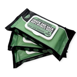 May include: A stack of green and black packaged intimate wipes. The top package features a white label with the text "CRACK AND SACK MEN'S INTIMATE WIPES" and "48 PACK". The label also includes the words "FRESH - CLEAN - REFRESHING".