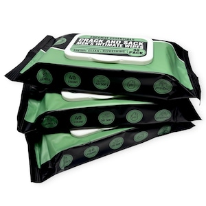 May include: A stack of four packages of intimate wipes. The packages are black and green with white text that reads "CRACK AND SACK MEN'S INTIMATE WIPES". Each package has a white dispenser and contains 40 wipes. The packaging also includes the words "Gentle", "50 Soft", "PH", and "Hygienic".