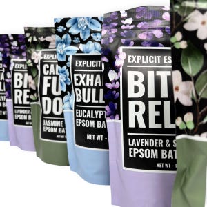 May include: A row of colorful bath salt pouches with floral designs. The pouches feature text like "Calm", "Exhale", and "Bit Rel". Each pouch has a different color scheme, including blue, green, and purple, with a black top.