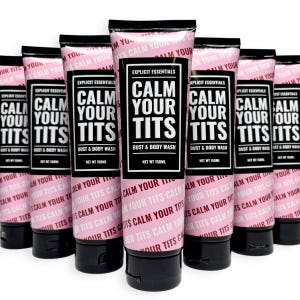 May include: A collection of pink tubes of "Calm Your Tits" bust and body wash. The tubes have black caps and feature the text "Explicit Essentials" and "Calm Your Tits" in a bold, black font.