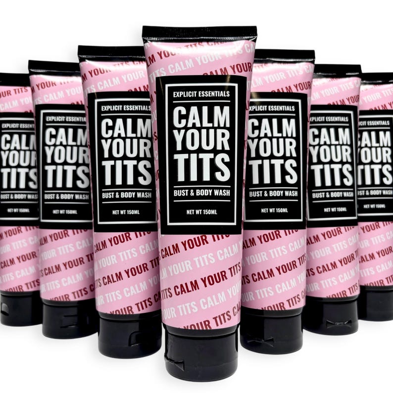 May include: A collection of pink tubes of "Calm Your Tits" bust and body wash. The tubes have black caps and feature the text "Explicit Essentials" and "Calm Your Tits" in a bold, black font.