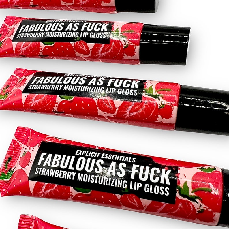 May include: Three tubes of strawberry flavored lip gloss with a red and white strawberry design. The tubes are labeled "EXPLICIT ESSENTIALS FABULOUS AS FUCK STRAWBERRY MOISTURIZING LIP GLOSS".