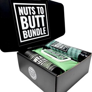 May include: A black gift box labelled "Nuts to Butt Bundle" contains several products. Inside are two tubes, a small rectangular package, and a green cloth. The tubes are black and green, and the package is white and green. The box has the words "You've got great taste" on it.