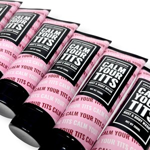 May include: Several pink tubes of "CALM YOUR TITS" bust and body wash are arranged in a row. Each tube has a black cap and a label with the product name in bold white letters on a black background. The net weight is 150ml.