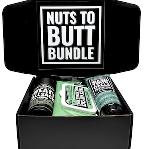 May include: A black gift box with the text "Nuts to Butt Bundle" on the lid. Inside are personal care items: a container of "Sweat Allsack" powder, "Crack and Sack" wipes, and a tube of "Wash Your Balls" body wash.