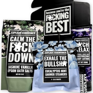 May include: A gift set featuring Explicit Essentials products. Includes Epsom bath salts, shower steamers, and body lotion. The packaging has floral designs and bold text like "Calm the F*ck Down" and "Exhale the Bullsh*t". The box says "because you're the F*cking Best".