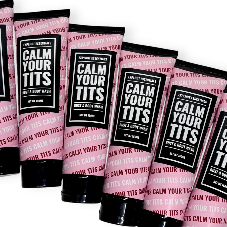 May include: Several pink tubes of bust and body wash are arranged in a row. Each tube has a black cap and features the text "CALM YOUR TITS" in a bold, white font. The product is labeled "Explicit Essentials" and contains 150ml.