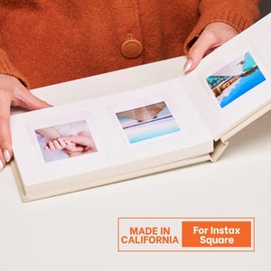 May include: Cream-colored photo album with three square photo slots, each holding a small photograph. The album is open, revealing the images. Text on the bottom reads "MADE IN CALIFORNIA" and "For Instax Square".