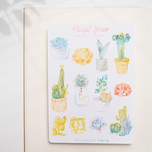 May include: A sheet of stickers featuring watercolor illustrations of succulents and cacti in various colors and styles. The stickers are titled "Blissful Spring Watercolor Succulents" and "Occasional Motto".