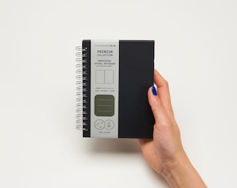May include: A black hardcover spiral notebook with the text "PREMIUM COLLECTION HARDCOVER SPIRAL NOTEBOOK" on the front cover.