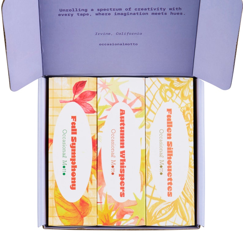 May include: Three decorative washi tape rolls with autumn-themed designs. The rolls are labelled "Fall Symphony", "Autumn Whispers", and "Fallen Silhouettes".