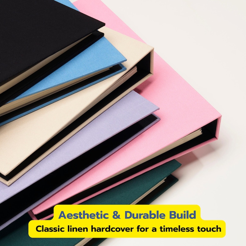 May include: A stack of hardcover books with linen covers in black, light blue, cream, lavender, pink, and dark green. A yellow rectangular label at the bottom displays the text: Aesthetic & Durable Build. Classic linen hardcover for a timeless touch.