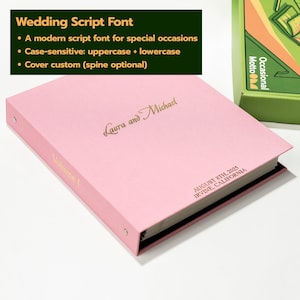 May include: A light pink binder featuring gold foil text that reads Laura and Michael, Volume I, and AUGUST 8TH, 2025 IRVINE, CALIFORNIA. The binder includes metal ring hardware on the side and is displayed next to a green box labeled Motto Occasional.