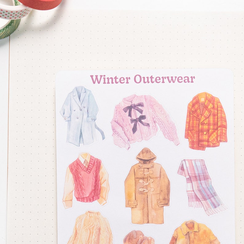 May include: A sheet of stickers featuring illustrations of winter outerwear, including a blue coat, a pink sweater with a bow, a plaid jacket, a red sweater vest, a brown peacoat, a plaid scarf, a cream sweater, a brown hat, and a brown leather jacket. The sheet is labeled "Winter Outerwear".