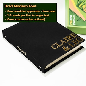 May include: A black hardcover book with gold foil lettering on the front cover reading CLAIRE & LEO and the text Volume I printed on the spine. The book features a textured finish and is positioned next to a green box with graphic illustrations.