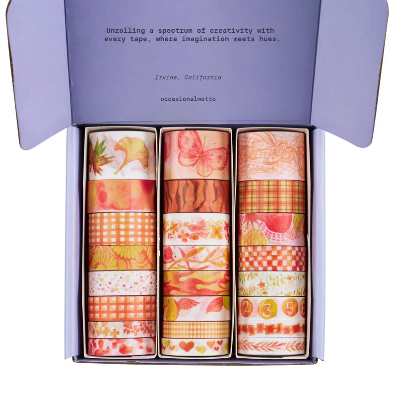 May include: A box containing 18 washi tapes. The tapes feature a variety of autumnal designs, including leaves, butterflies, and gingham patterns. The tapes are in shades of orange, yellow, and red.