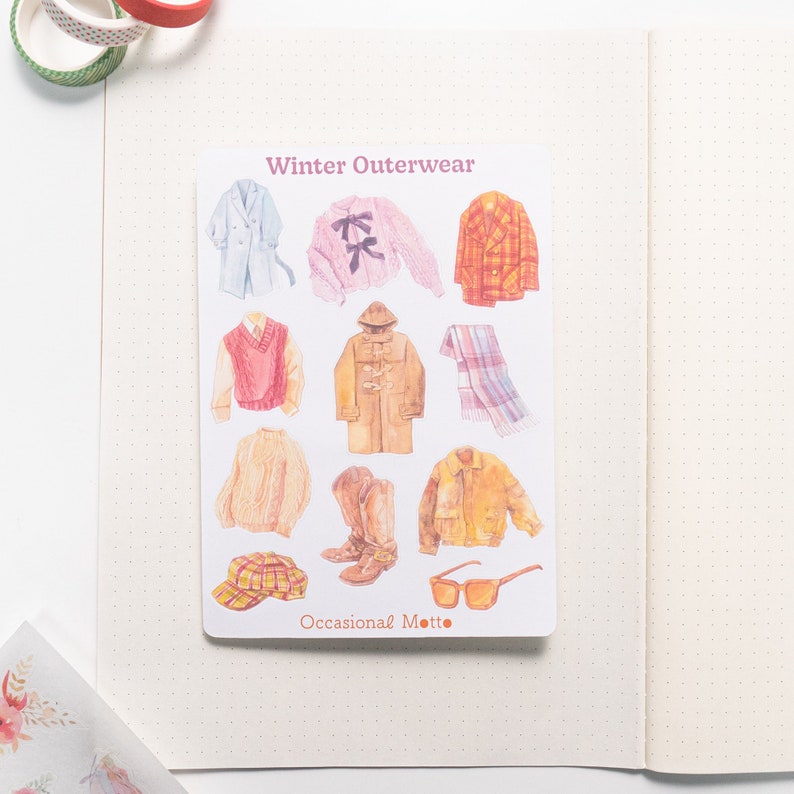 May include: A sheet of stickers featuring illustrations of winter outerwear, including a coat, sweater, scarf, hat, boots, and sunglasses. The sheet is titled "Winter Outerwear" and "Occasional Motto".