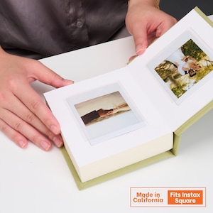Könnte beinhalten: Ein salbeigrünes Fotoalbum mit weißen Seiten, das zwei quadratische Sofortbilder enthält. Das linke Foto zeigt zwei Hände, die sich halten, und das rechte Foto zeigt ein Paar im Freien. Der Einband ist salbeigrün und hat einen quadratischen Ausschnitt.