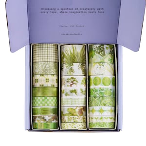 May include: A set of decorative washi tapes in a box. The tapes feature various green patterns, including leaves and geometric designs. The box lid reads "Unrolling a spectrum of creativity with every tape, where imagination meets hues."