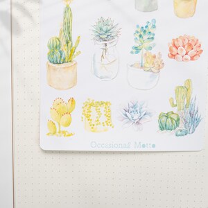 May include: A sheet of stickers featuring watercolor illustrations of various succulents and cacti in pots. The stickers are on a white background and have the text "Occasional Motto" at the bottom.