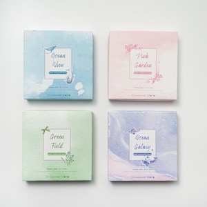 May include: Four boxes of decorative stickers with watercolor designs. The boxes are labeled "Ocean View", "Pink Garden", "Green Field", and "Ocean Galaxy". Each box has a sticker size of 4.8 x 6.8 inches and is labeled "Occasional Matte".