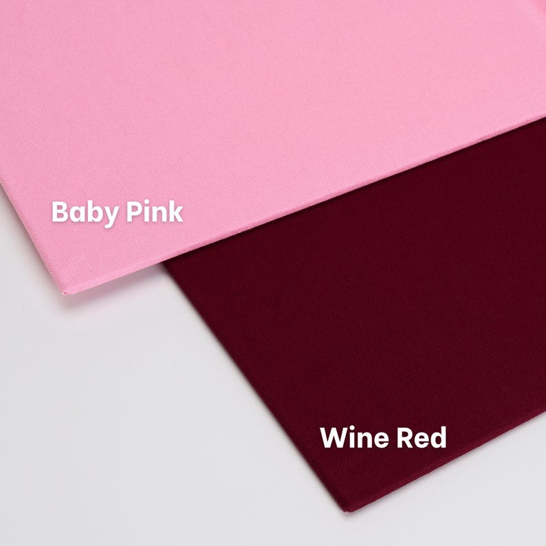 May include: Two rectangular fabric swatches are displayed. The top swatch is a solid baby pink color with the text Baby Pink printed in white. The bottom swatch is a solid wine red color with the text Wine Red printed in white on the fabric.