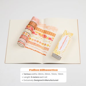May include: A set of 10 washi tapes with various autumn-themed designs in shades of orange, yellow, and white. The tapes are arranged in a fan shape on a white surface. The text "Fallen Silhouettes" is printed on the box. The tapes are 5 metres long and come in various widths: 30mm, 20mm, 15mm, and 10mm.