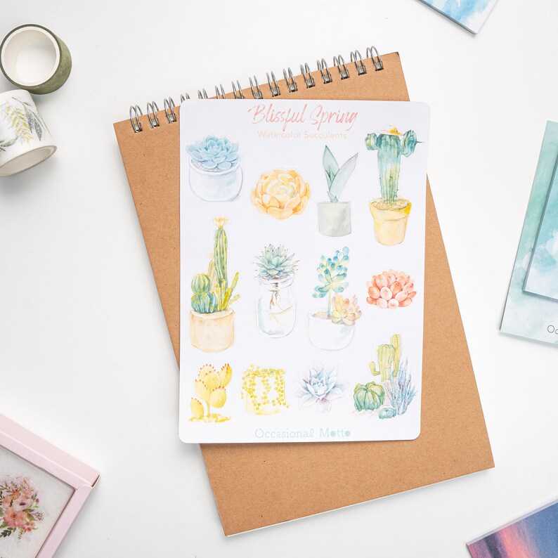 May include: A sheet of stickers featuring watercolor illustrations of succulents and cacti in various colors and styles. The stickers are titled "Blissful Spring Watercolor Succulents" and "Occasional Note".