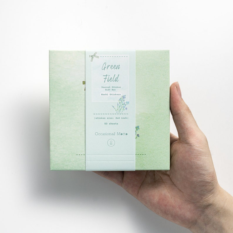 May include: A green box with a white label that says "Green Field" and features a floral design. The label also says "Journal Sticker Gift Box", "Washi Stickers", "sticker size: 4x4 inch", "50 sheets", and "Occasional Mette".