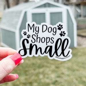 May include: White sticker with black text that reads "My Dog Shops Small" with paw prints and the social media handle "@sewdoggyboutique".
