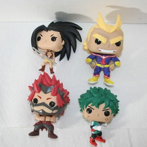 May include: Four collectible vinyl figures of characters from the anime series My Hero Academia. The figures are of All Might, Izuku Midoriya, Katsuki Bakugo, and Ochaco Uraraka. The figures are all in their signature poses and outfits.