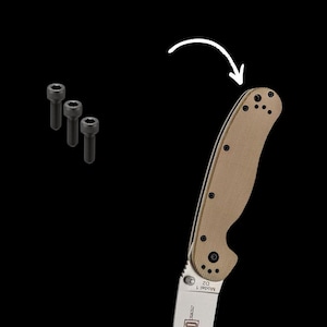 May include: A tan knife handle with a silver blade and black screws. The handle has a textured surface and the text "Model 1 D2" is printed on the blade.