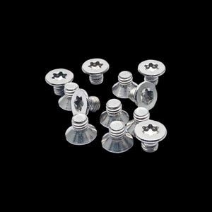 Puede incluir: Un grupo de tornillos plateados con cabeza de estrella. Los tornillos están esparcidos sobre un fondo negro.