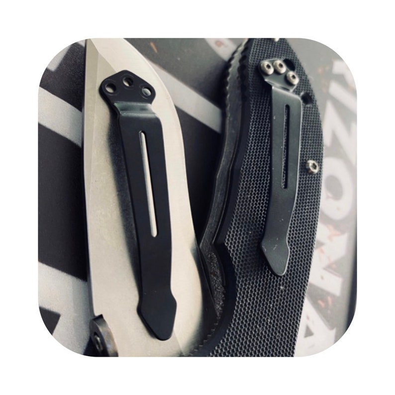 May include: Two pocket knives with black pocket clips. The knives have different handle materials, one is silver and the other is black.