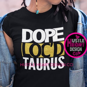 Puede incluir: Camiseta negra con letras doradas que dicen "Dope Loc'd Taurus" y un pequeño logotipo rosa que dice "Hustle Heart Design Co."